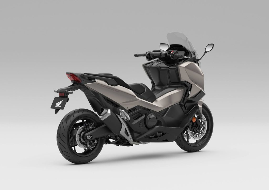 Honda Forza 750 modelo 2027 estacionada em ambiente urbano, exibindo uma das novas opções de cor, destacando seu design sofisticado e linhas esportivas.