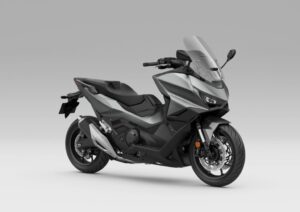 Honda Forza 750 modelo 2027 estacionada em ambiente urbano, exibindo uma das novas opções de cor, destacando seu design sofisticado e linhas esportivas.