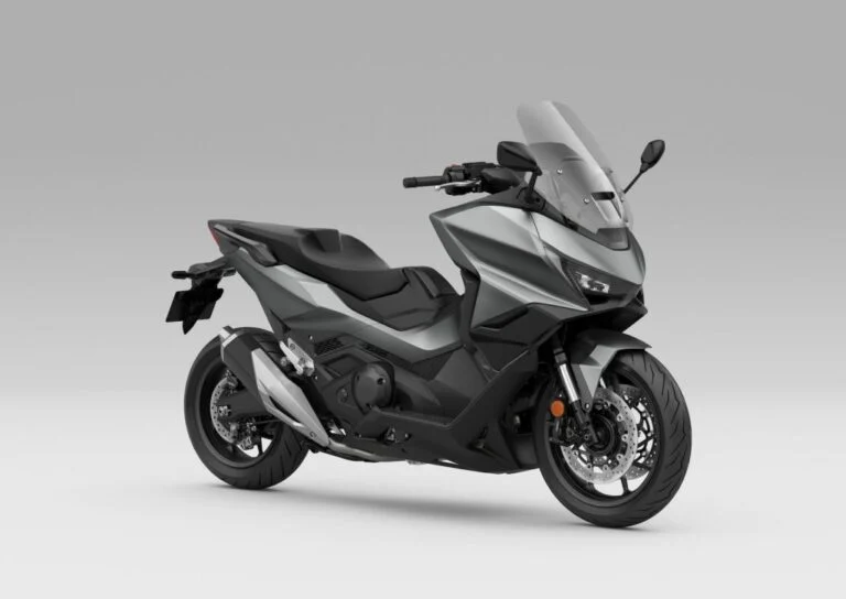 Honda Forza 750 modelo 2027 estacionada em ambiente urbano, exibindo uma das novas opções de cor, destacando seu design sofisticado e linhas esportivas.