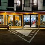Fachada do Motorcycle Inn, um hotel temático nos EUA, com motocicletas clássicas em exibição e arquitetura convidativa para motociclistas.