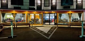 Fachada do Motorcycle Inn, um hotel temático nos EUA, com motocicletas clássicas em exibição e arquitetura convidativa para motociclistas.