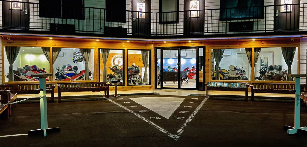 Fachada do Motorcycle Inn, um hotel temático nos EUA, com motocicletas clássicas em exibição e arquitetura convidativa para motociclistas.