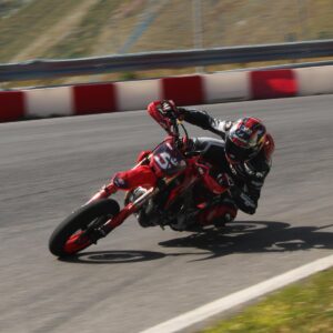 Johann Zarco pilotando uma moto Supermotard em um circuito, testando seu joelho esquerdo após lesão, com foco na sua técnica e agilidade em curva e sua concentração.