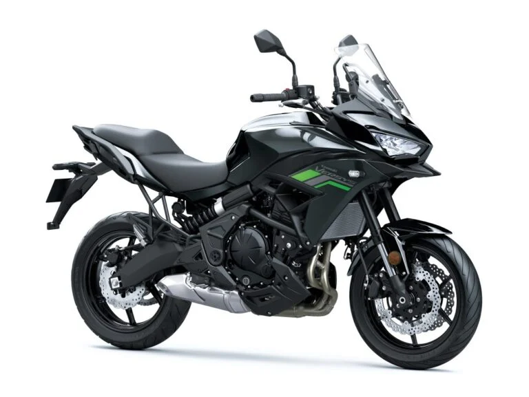 Detalhe da Kawasaki Versys 650 2027 em uma estrada sinuosa, destacando seu design atraente e iluminação LED, ideal para mototurismo e uso urbano.