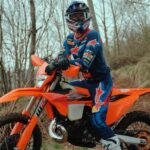 Mani Lettenbichler, piloto de enduro, testando a nova KTM 300 EXC 2027 em trilhas rochosas e desafiadoras, demonstrando a agilidade e potência do modelo.
