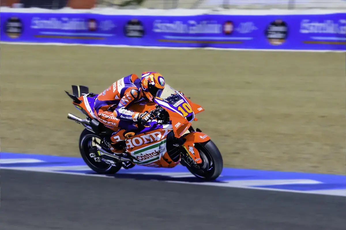 Luca Marini em sua moto Honda RC213V em alta velocidade durante uma corrida de MotoGP, com foco na sua performance.