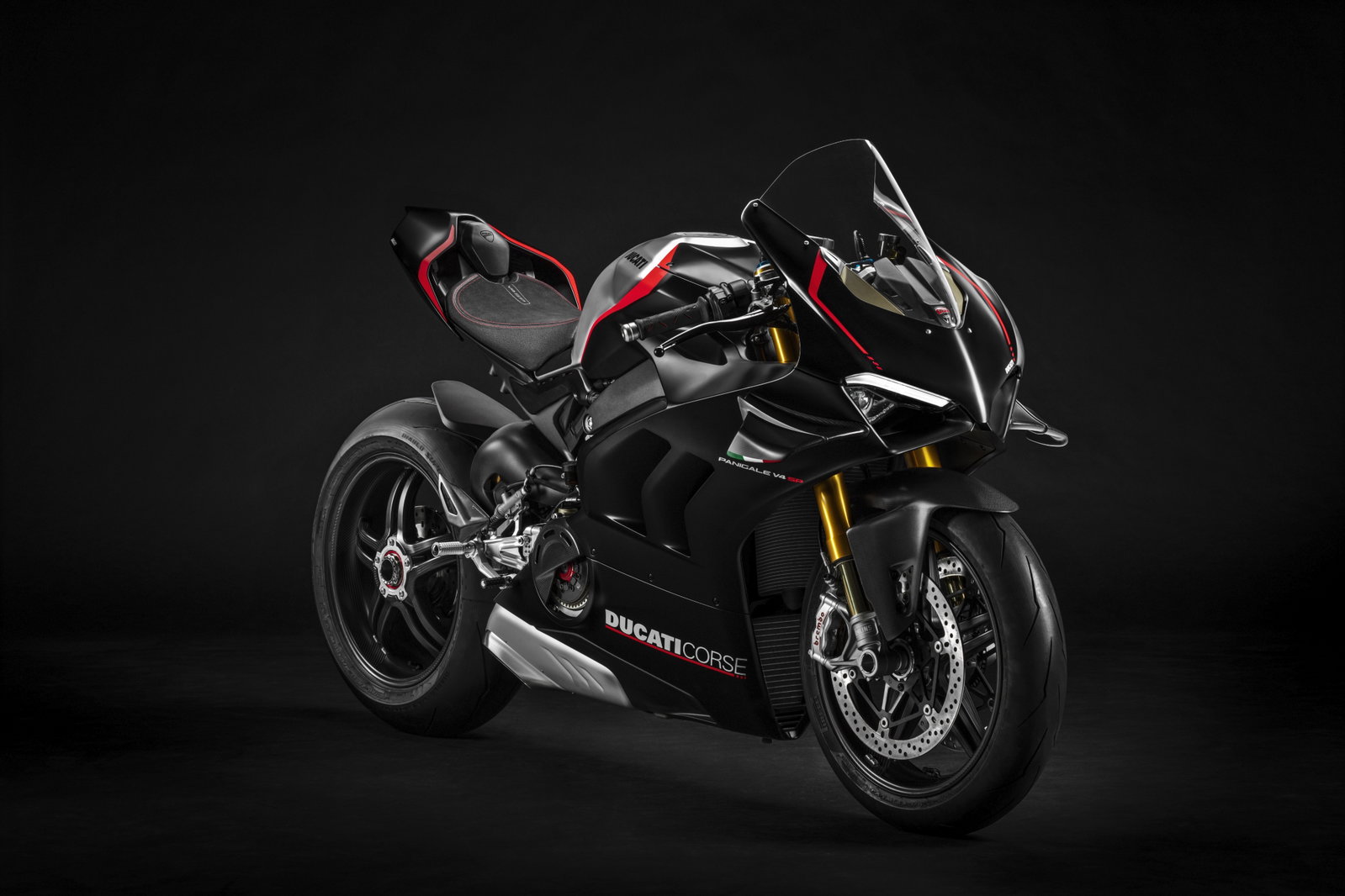 Detalhe de uma Ducati Panigale V4 SP em ação em pista, destacando seu design agressivo e componentes de alta performance, como suspensões Öhlins e rodas leves.