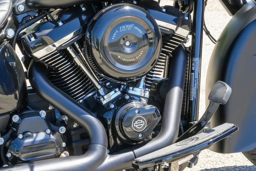 Harley-Davidson Deadwood 2026, uma cruiser Softail na cor Denim Black, exibindo seu assento solo, para-brisa recortado e rodas escuras.