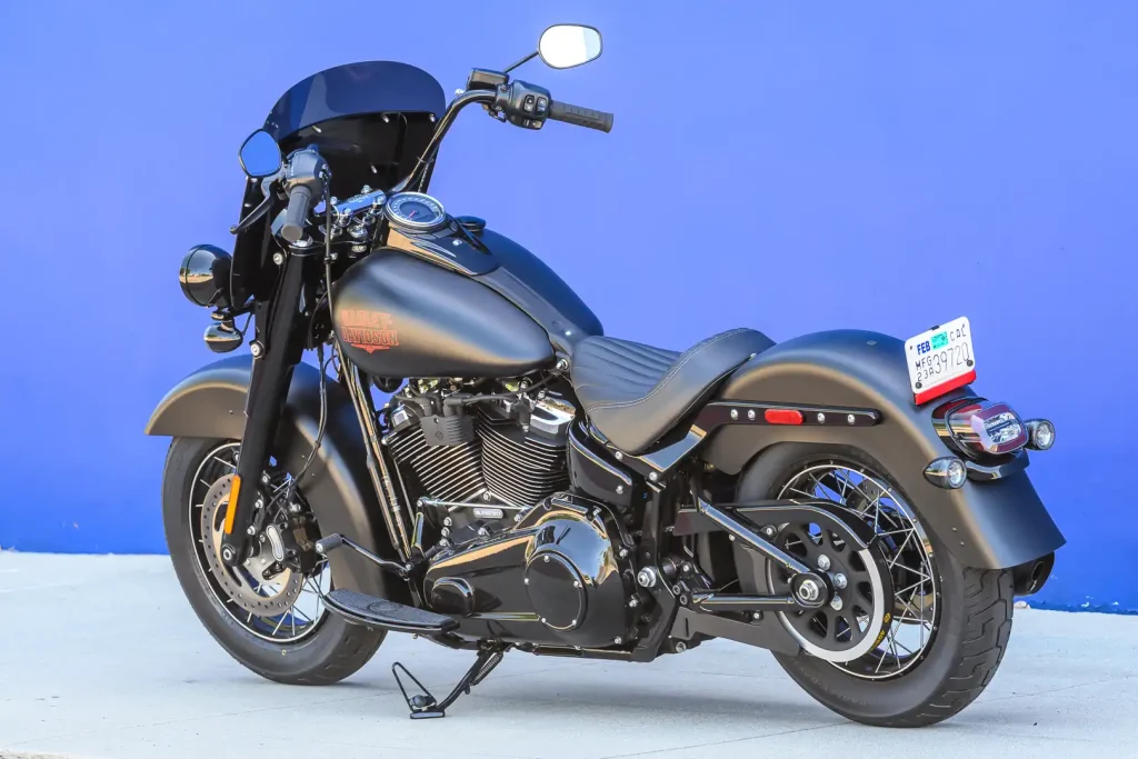 Harley-Davidson Deadwood 2026, uma cruiser Softail na cor Denim Black, exibindo seu assento solo, para-brisa recortado e rodas escuras.