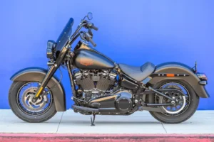 Harley-Davidson Deadwood 2026, uma cruiser Softail na cor Denim Black, exibindo seu assento solo, para-brisa recortado e rodas escuras.