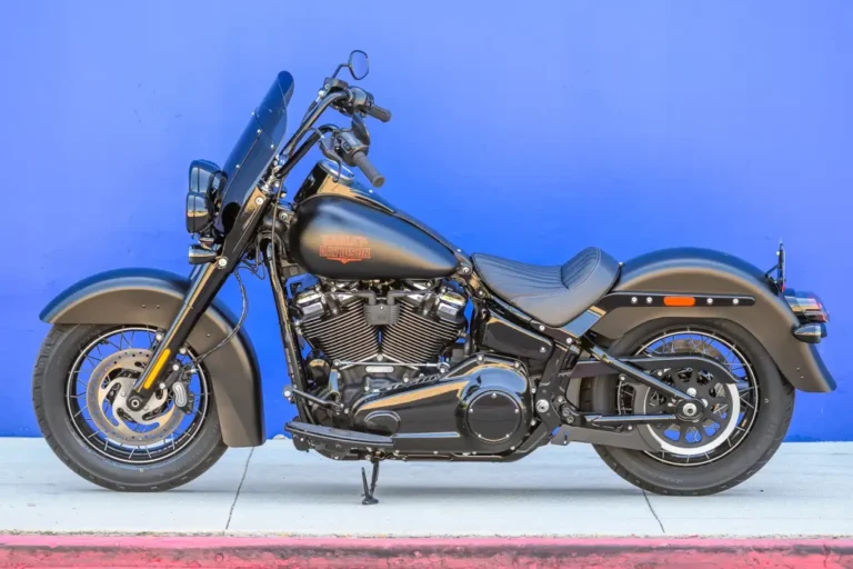Harley-Davidson Deadwood 2026, uma cruiser Softail na cor Denim Black, exibindo seu assento solo, para-brisa recortado e rodas escuras.