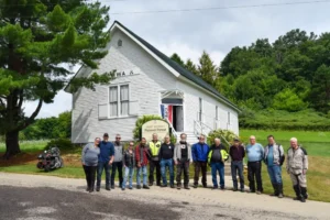Motociclistas da Moto Guzzi reunidos em um rally em Wisconsin, preparando-se para a aventura pela Floresta Pintada.