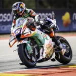 Johann Zarco em sua moto Honda RC213V, realizando uma curva em alta velocidade durante os treinos livres do MotoGP no circuito de MotorLand Aragón, com a pista ao fundo.