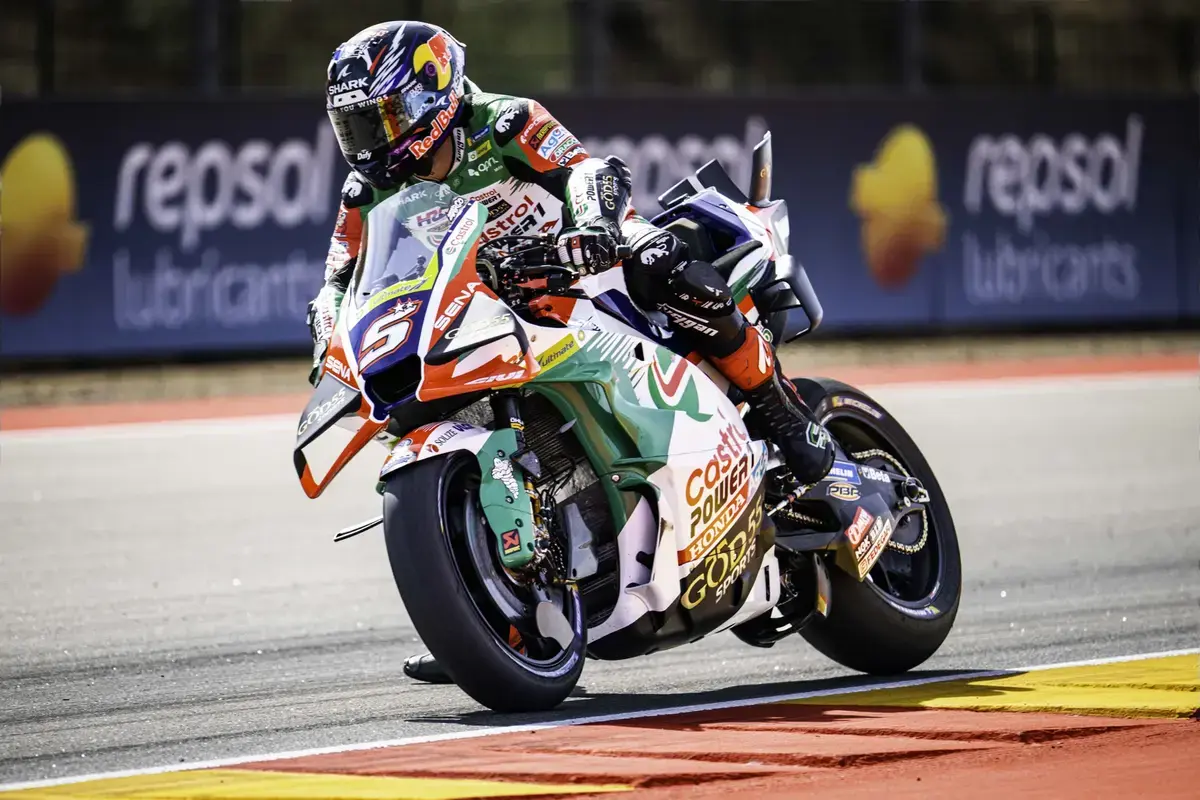 Johann Zarco em sua moto Honda RC213V, realizando uma curva em alta velocidade durante os treinos livres do MotoGP no circuito de MotorLand Aragón, com a pista ao fundo.