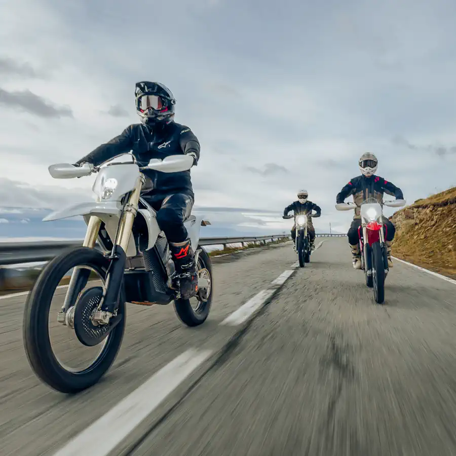 Uma motocicleta elétrica de enduro Stark Varg EX em alta velocidade, levantando poeira em uma trilha off-road, demonstrando agilidade e potência em terreno acidentado.