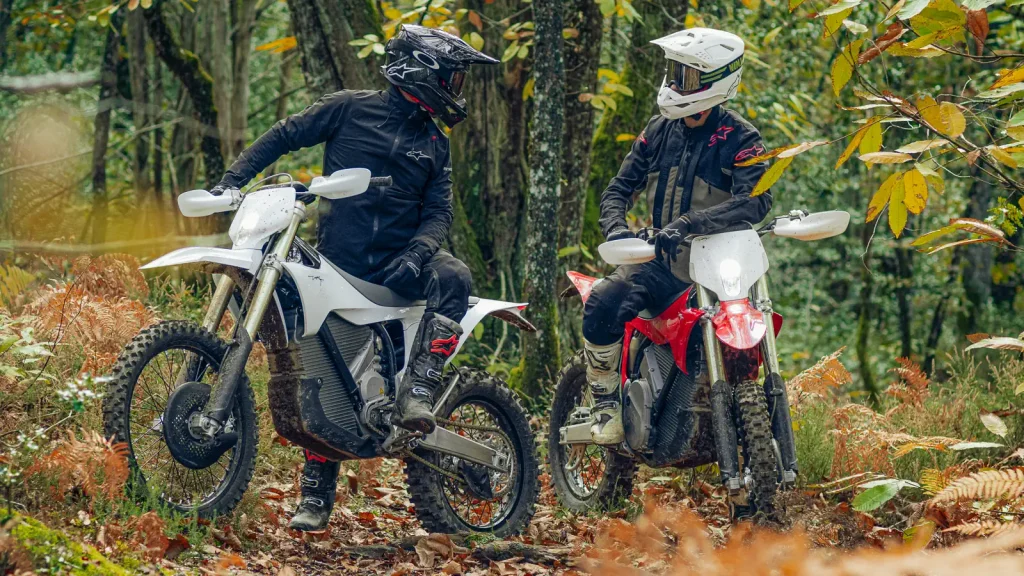 Uma motocicleta elétrica de enduro Stark Varg EX em alta velocidade, levantando poeira em uma trilha off-road, demonstrando agilidade e potência em terreno acidentado.