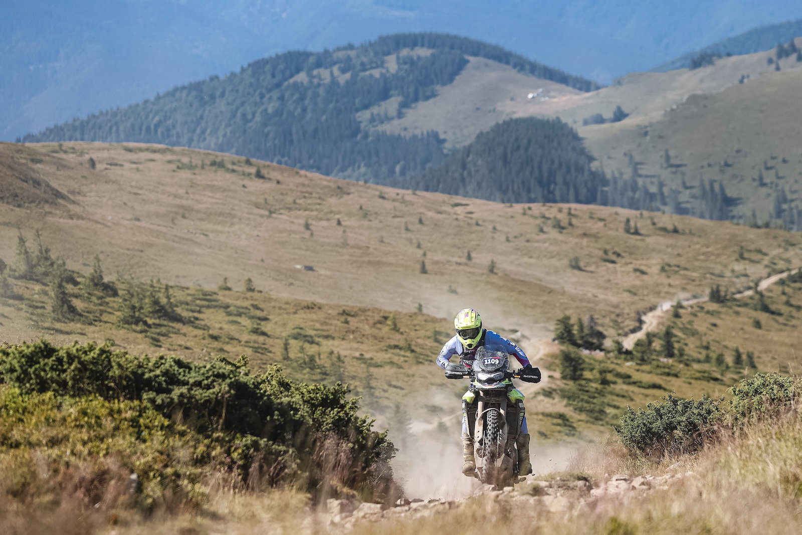 Sam Sunderland pilotando uma Triumph Tiger 900 Rally Pro em terreno rochoso e acidentado durante o Red Bull Romaniacs, conquistando o pódio em 2024.