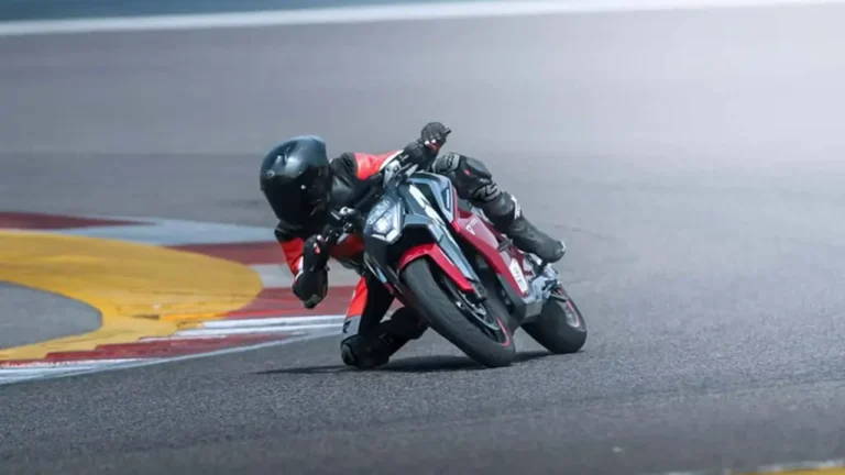 Motociclistas em curso de pilotagem na Ultraviolette Riding Academy com motocicletas elétricas da marca em pista de asfalto, sob a supervisão de instrutores.