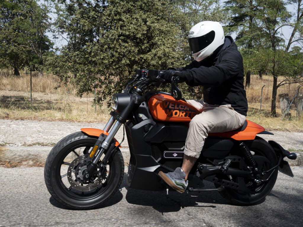 Velca Vortex Black Edition, uma motocicleta elétrica com design moderno e elegante em acabamento preto fosco, estacionada em um ambiente urbano.