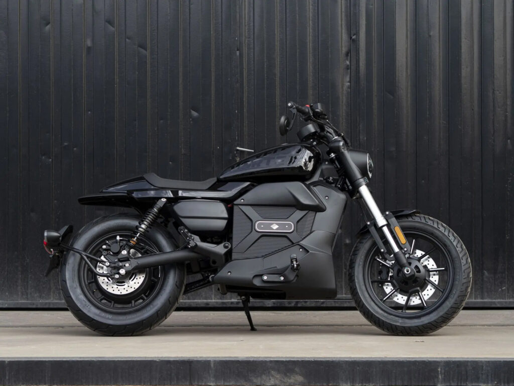 Velca Vortex Black Edition, uma motocicleta elétrica com design moderno e elegante em acabamento preto fosco, estacionada em um ambiente urbano.