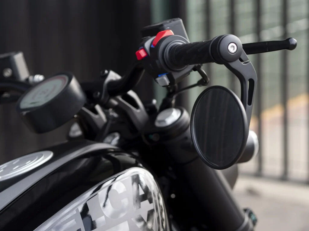 Velca Vortex Black Edition, uma motocicleta elétrica com design moderno e elegante em acabamento preto fosco, estacionada em um ambiente urbano.