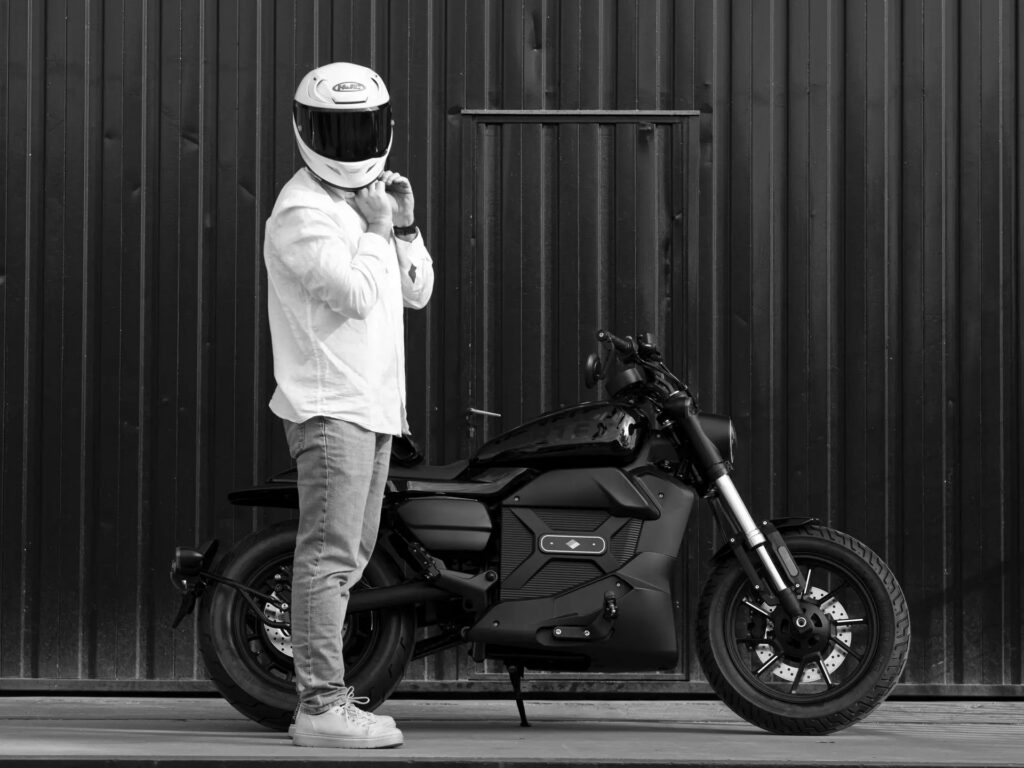 Velca Vortex Black Edition, uma motocicleta elétrica com design moderno e elegante em acabamento preto fosco, estacionada em um ambiente urbano.