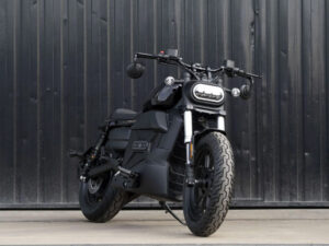 Velca Vortex Black Edition, uma motocicleta elétrica com design moderno e elegante em acabamento preto fosco, estacionada em um ambiente urbano.