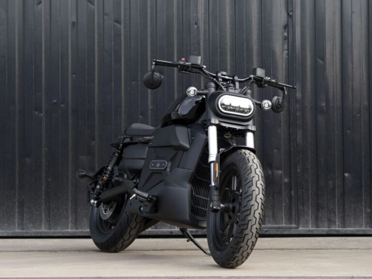 Velca Vortex Black Edition, uma motocicleta elétrica com design moderno e elegante em acabamento preto fosco, estacionada em um ambiente urbano.