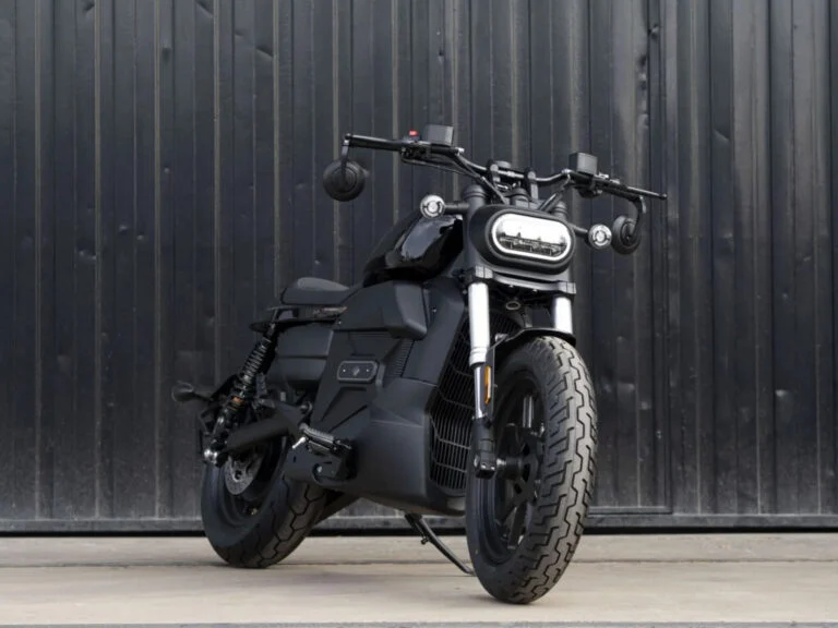 Velca Vortex Black Edition, uma motocicleta elétrica com design moderno e elegante em acabamento preto fosco, estacionada em um ambiente urbano.