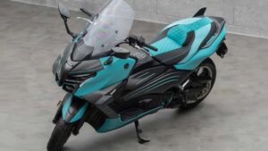 Vista frontal detalhada de uma Yamaha TMAX personalizada pela Mansory, destacando os winglets aerodinâmicos e os componentes em fibra de carbono, com acabamento luxuoso e agressivo.