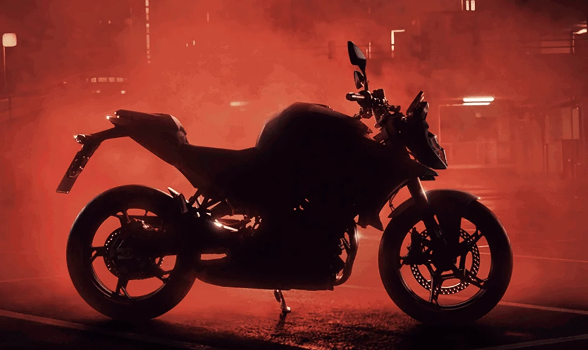 Teaser da BMW F450 R, uma motocicleta naked com motor bicilíndrico paralela, exibindo seu novo design com farol escalonado e contorno musculoso em ambiente urbano.