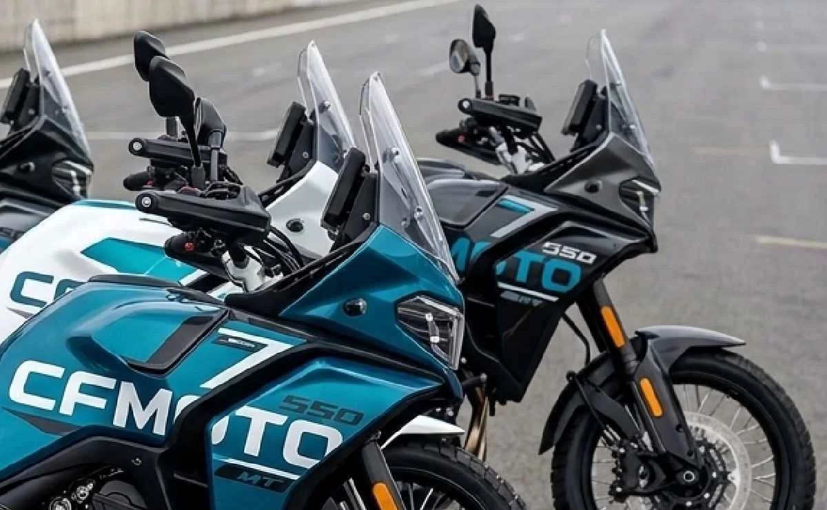 Protótipo camuflado da nova CFMoto 550MT big trail sendo testado em pista, com design que remete ao rali e rodas raiadas.