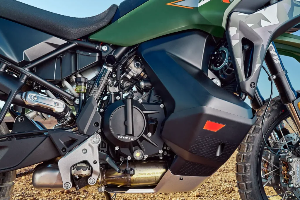 Detalhe da frente da CFMoto Ibex 950 Adventure Bike, mostrando seu design agressivo, faróis de LED e suspensão dianteira de longo curso.