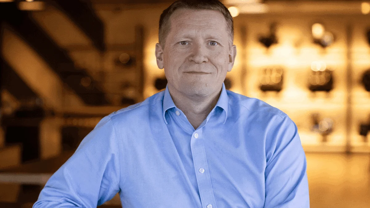 Paul Stroud, Chief Commercial Officer da Triumph Motorcycles, sorrindo em um evento da marca, representando seu legado de crescimento.