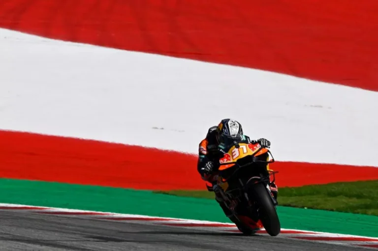 Pedro Acosta, piloto da KTM, acelerando sua motocicleta RC16 durante o Grande Prêmio da Áustria de MotoGP no Red Bull Ring, com destaque para seu capacete e postura aerodinâmica.
