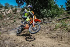Ruben Ferreira pilotando sua KTM em alta velocidade em trilha de enduro com poeira, durante o Campeonato Nacional de Enduro Sprint em Seia.
