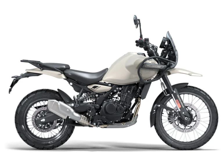 Royal Enfield Himalayan 450 na cor Kaza Brown estacionada em terreno de terra, destacando seu design adventure e detalhes de acabamento.