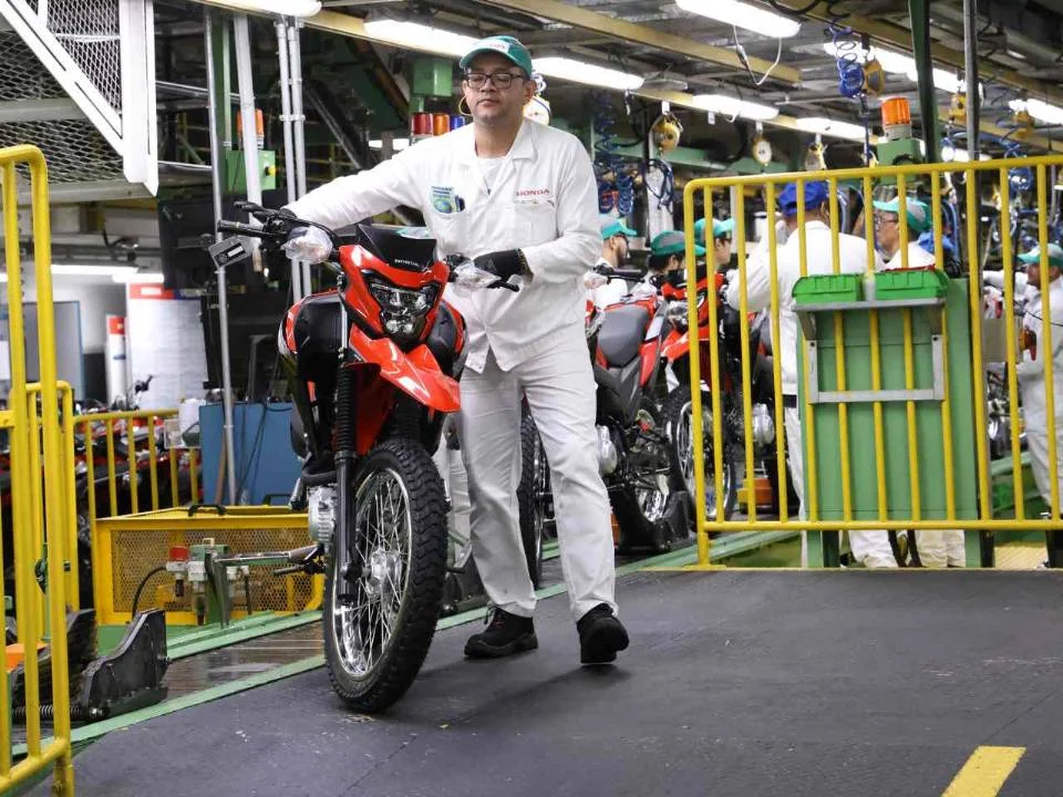 Fábrica da Honda em Manaus, Amazonas, mostrando linhas de montagem automatizadas e a imponente estrutura que produz mais de um milhão de motocicletas por ano.