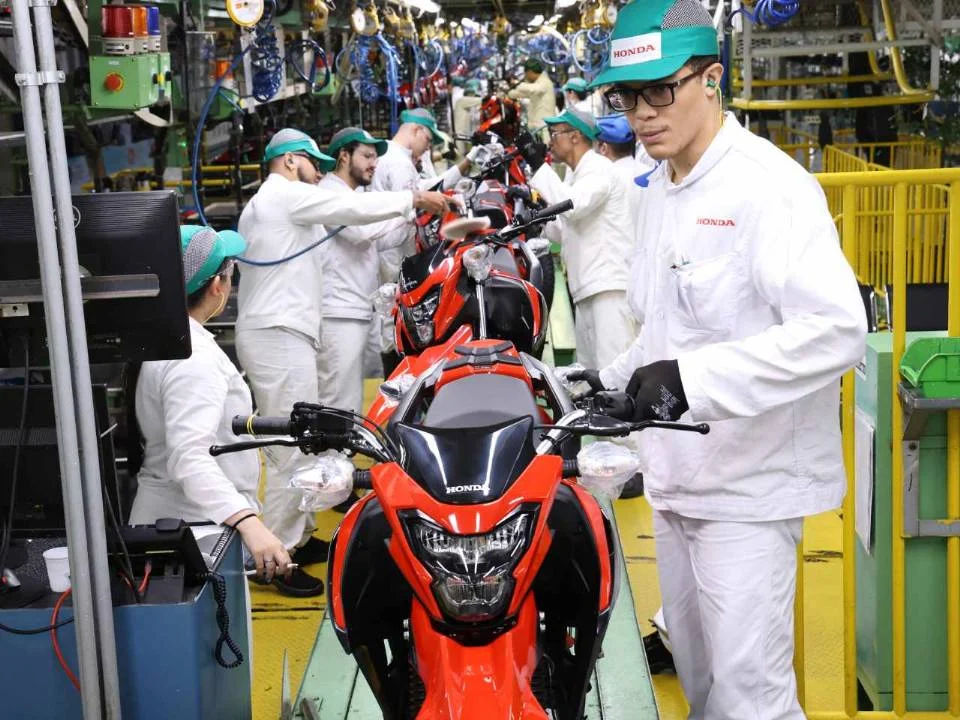 Fábrica da Honda em Manaus, Amazonas, mostrando linhas de montagem automatizadas e a imponente estrutura que produz mais de um milhão de motocicletas por ano.