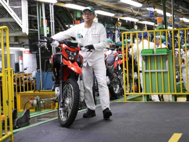 Fábrica da Honda em Manaus, Amazonas, mostrando linhas de montagem automatizadas e a imponente estrutura que produz mais de um milhão de motocicletas por ano.