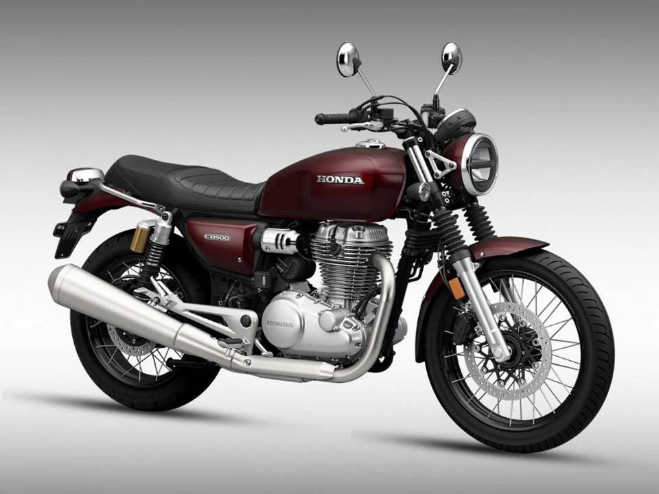 Honda CB500 neo café racer em destaque, mostrando o tanque arredondado e rodas raiadas, inspirado na clássica CB750