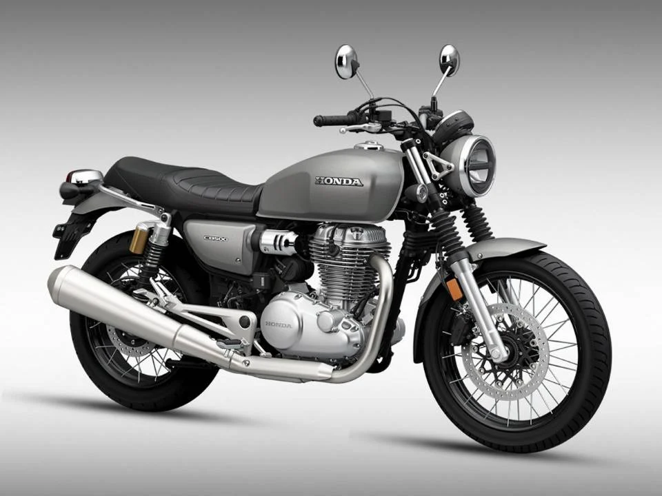 Honda CB500 neo café racer em destaque, mostrando o tanque arredondado e rodas raiadas, inspirado na clássica CB750