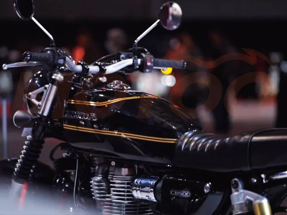 Honda CB500 neo café racer em destaque, mostrando o tanque arredondado e rodas raiadas, inspirado na clássica CB750
