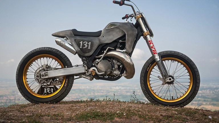 Kawasaki KX250 custom com carroceria de alumínio superleggera, exibindo estrutura tubular e acabamento escuro sem pintura