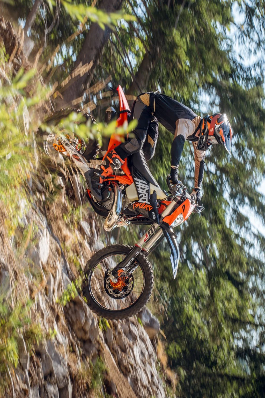KTM 300 XCW HardEnduro em ação, superando uma subida íngreme e rochosa em uma trilha off-road, mostrando sua capacidade extrema.