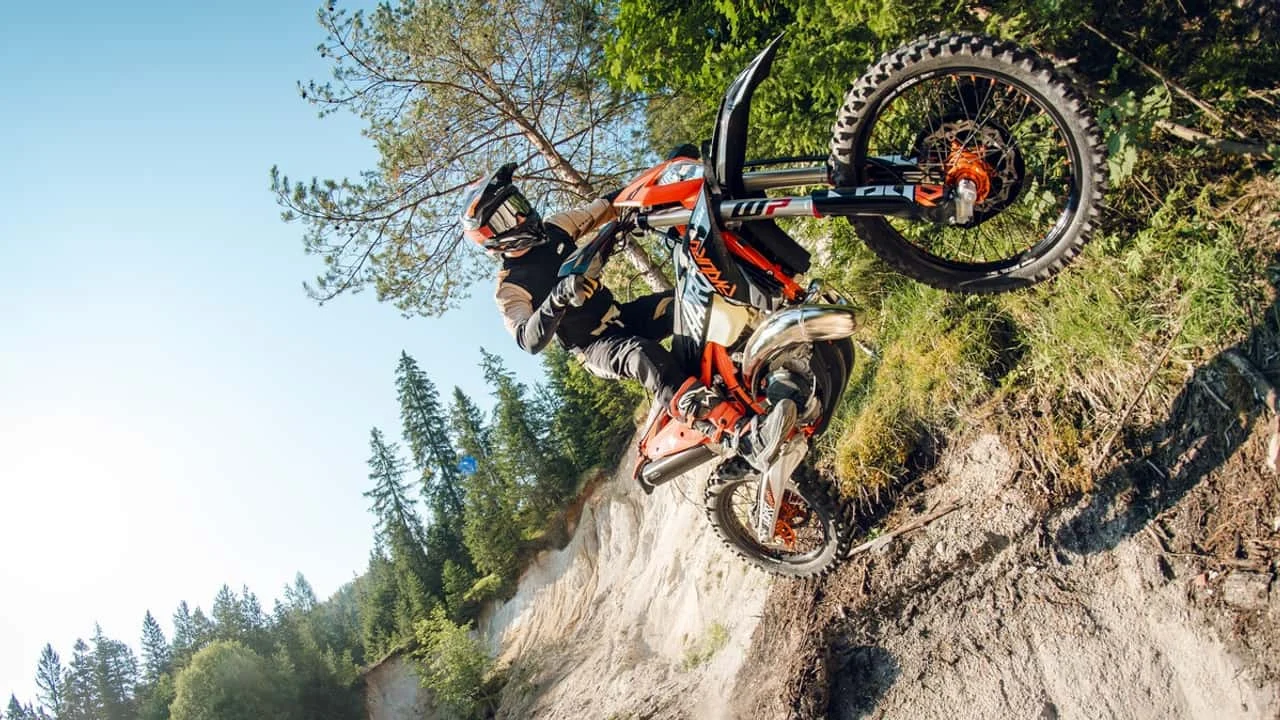 KTM 300 XCW HardEnduro em ação, superando uma subida íngreme e rochosa em uma trilha off-road, mostrando sua capacidade extrema.