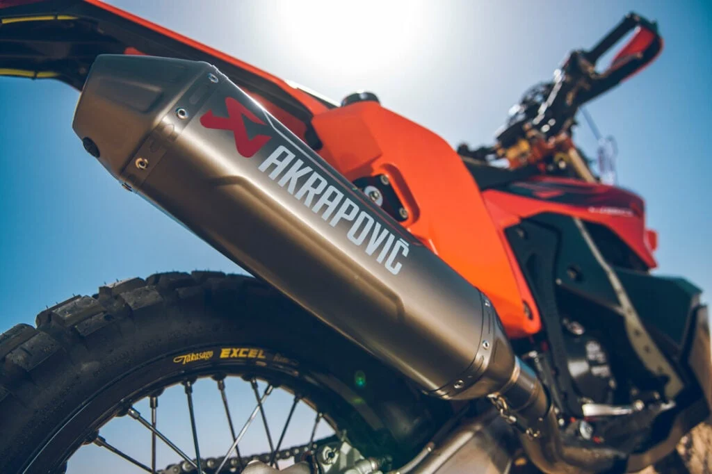 KTM 450 Rally Replica em destaque, mostrando motor monocilíndrico, quadro de aço cromado e escapamento Akrapovič de titânio