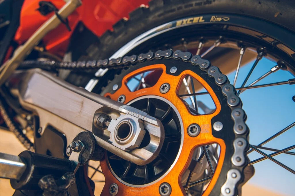 KTM 450 Rally Replica em destaque, mostrando motor monocilíndrico, quadro de aço cromado e escapamento Akrapovič de titânio