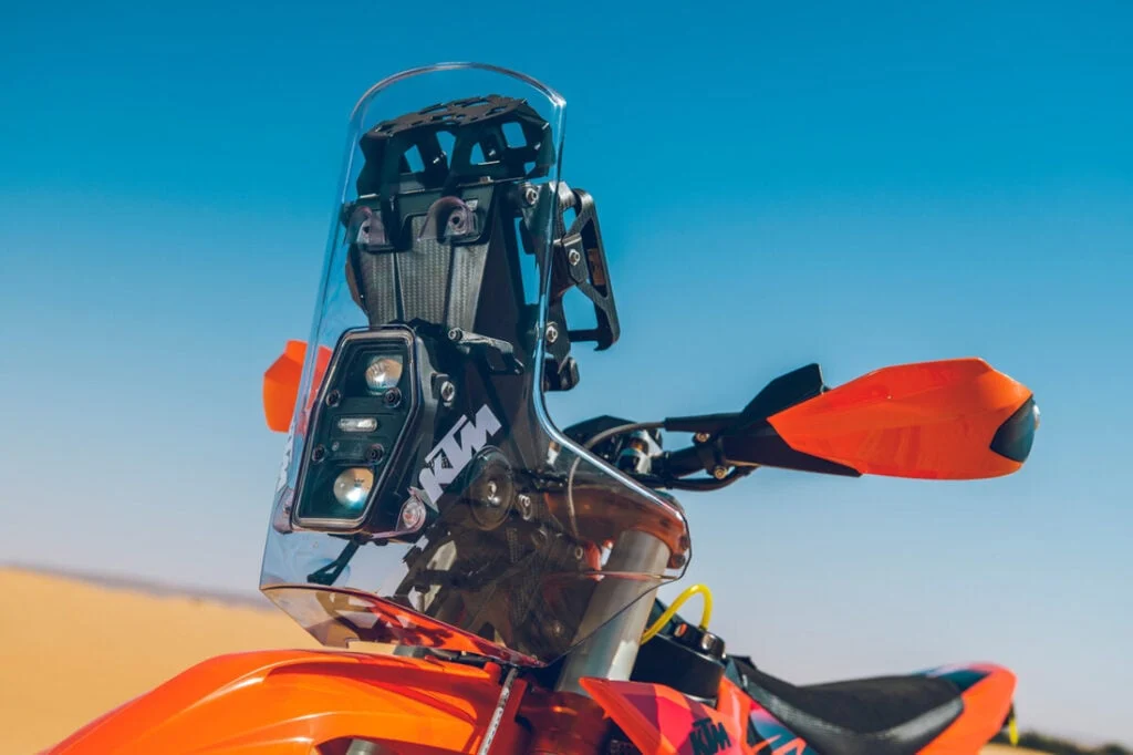 KTM 450 Rally Replica em destaque, mostrando motor monocilíndrico, quadro de aço cromado e escapamento Akrapovič de titânio