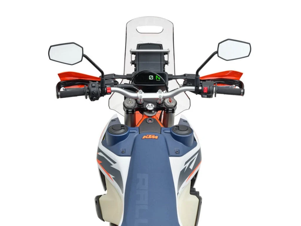 KTM 690 Rally 2027 em destaque, exibindo seu design robusto e pronto para rali, com carenagem de competição e tanque de combustível de grande capacidade.
